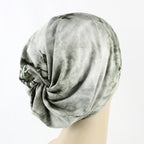 Gray patterned headscarf on a mannequin head against a white background