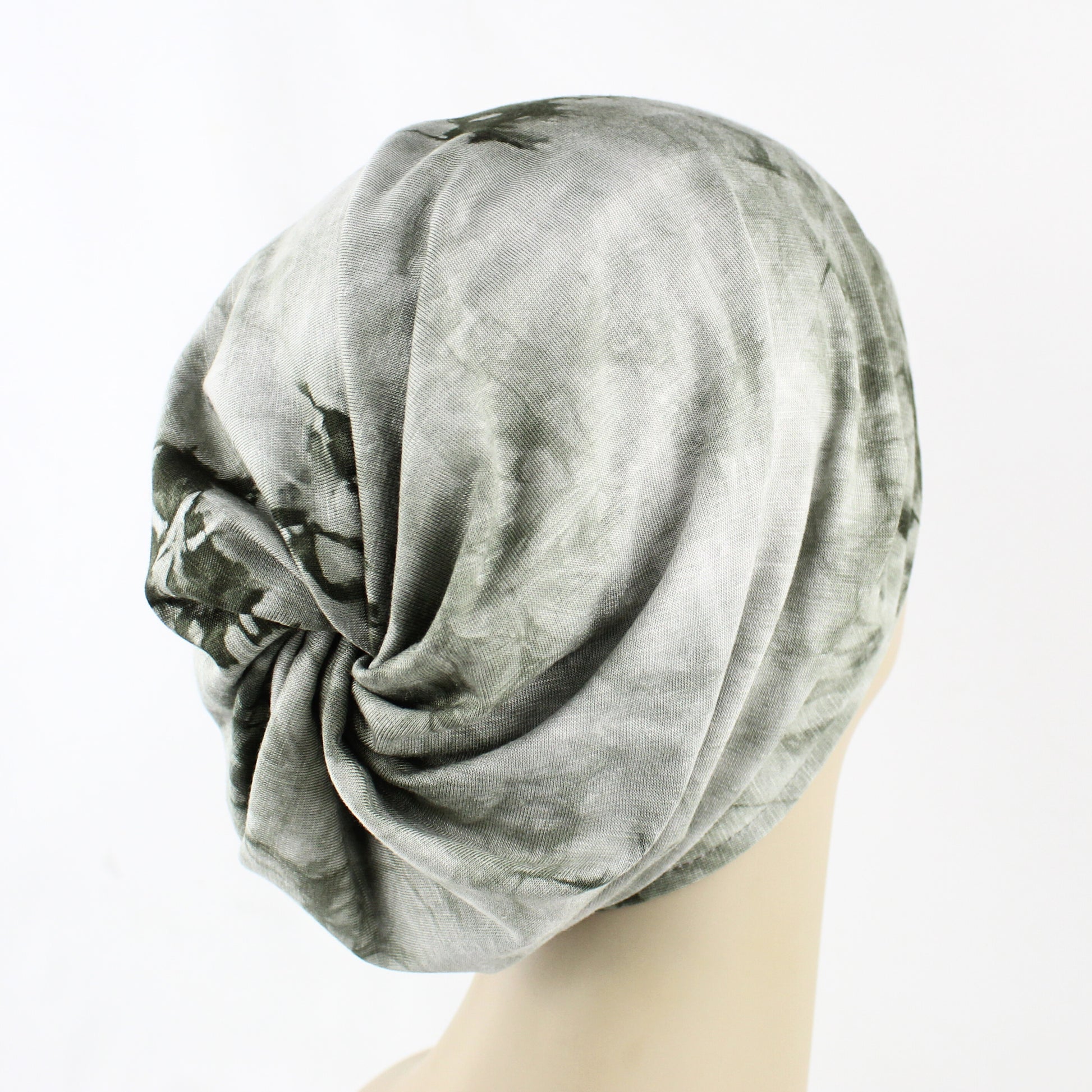 Gray patterned headscarf on a mannequin head against a white background