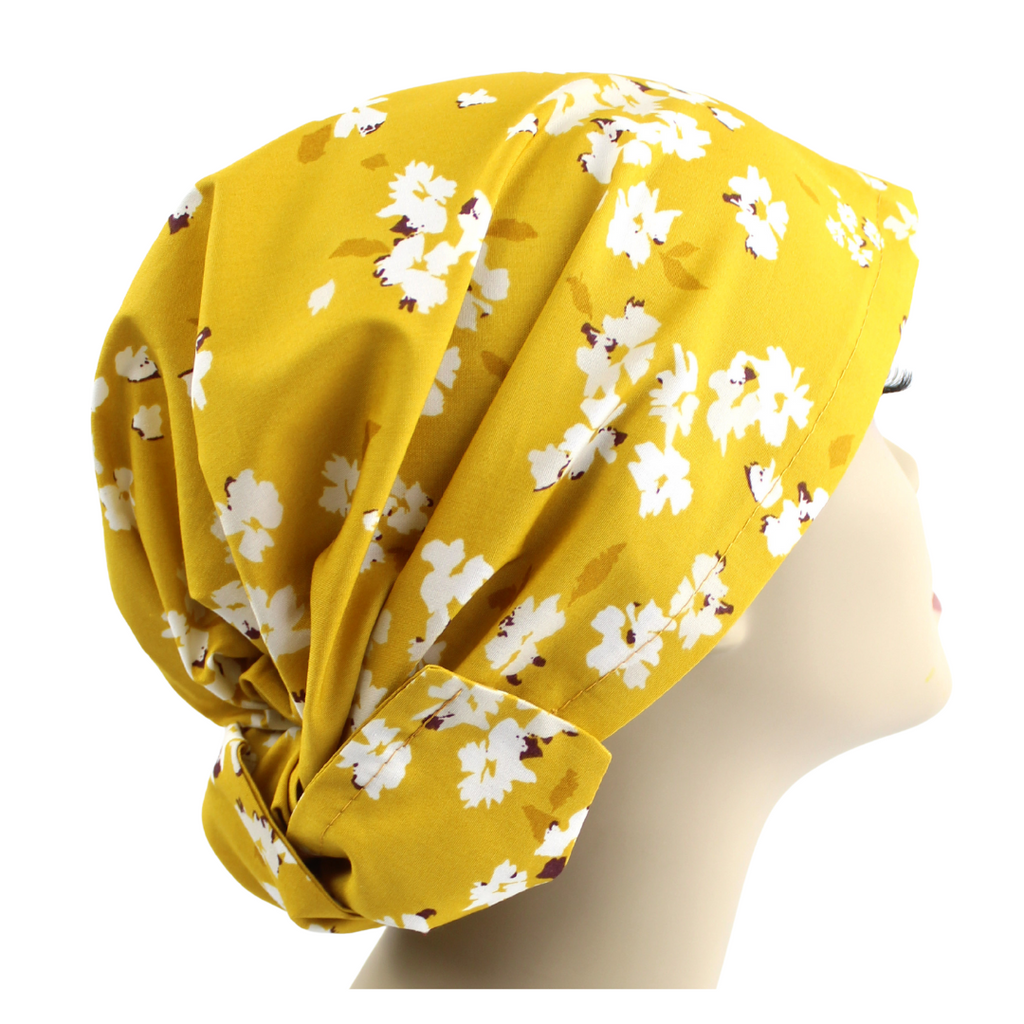 A yellow floral hair wrap on a mannequin head.