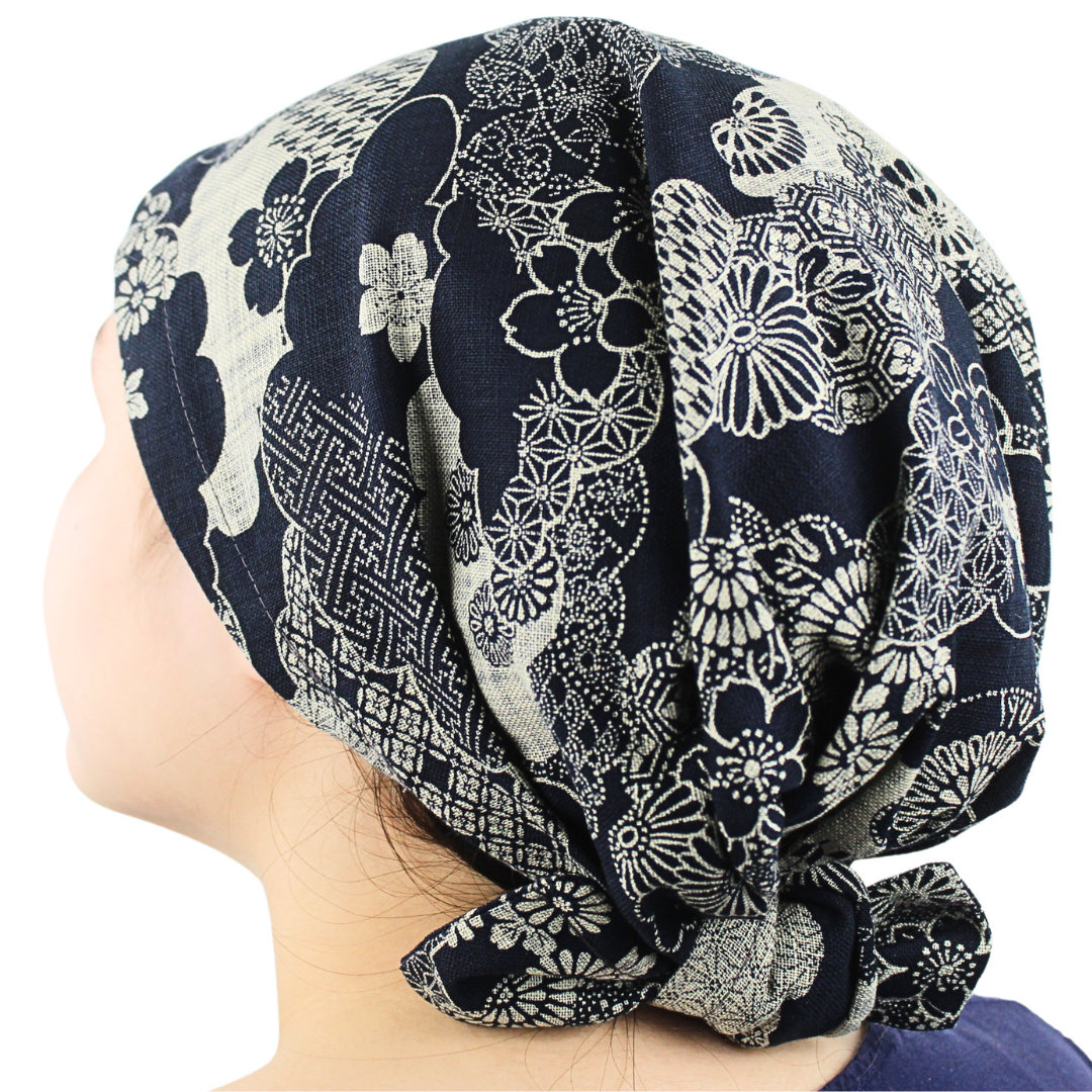 Navy blue and white floral patterned headscarf on a person against a white background