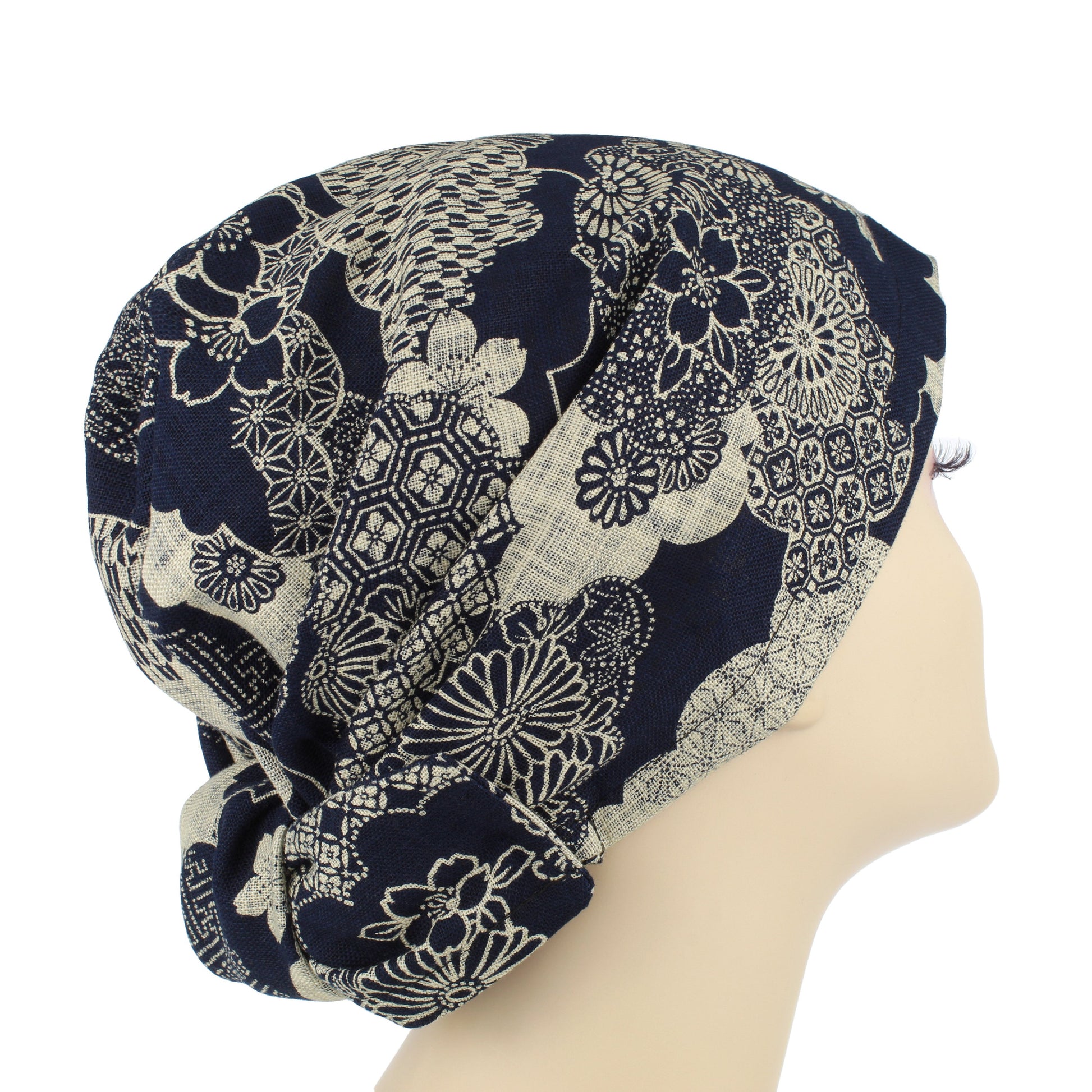 A navy blue floral hair wrap with large fabric ties, displayed on a mannequin head.