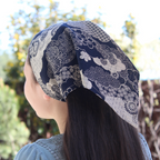 Person wearing a blue and white patterned headscarf outdoors