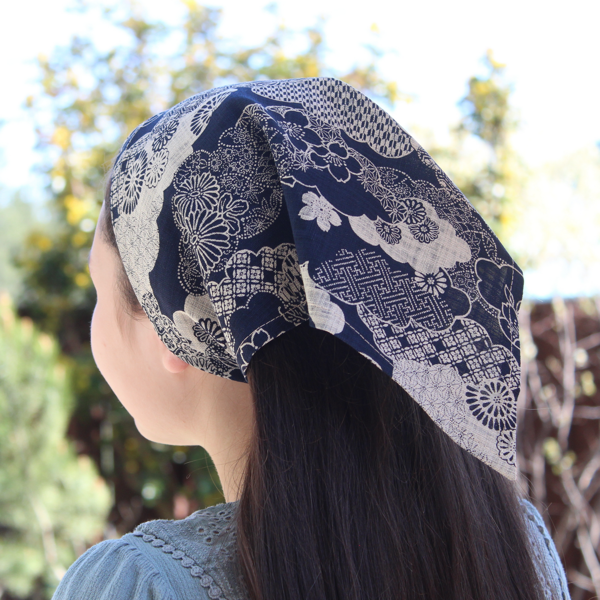 Person wearing a blue and white patterned headscarf outdoors